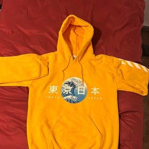 An orange hoodie with Tokyo Japan writing